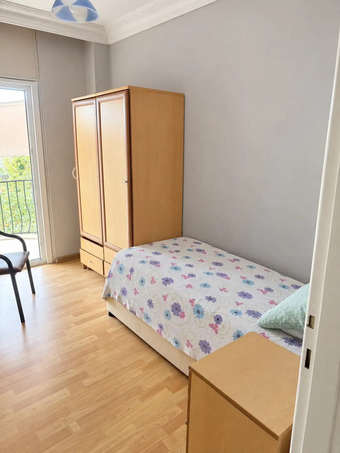 Balkon kapılı, ahşap gardıroplu ve tek yataklı aydınlık oda