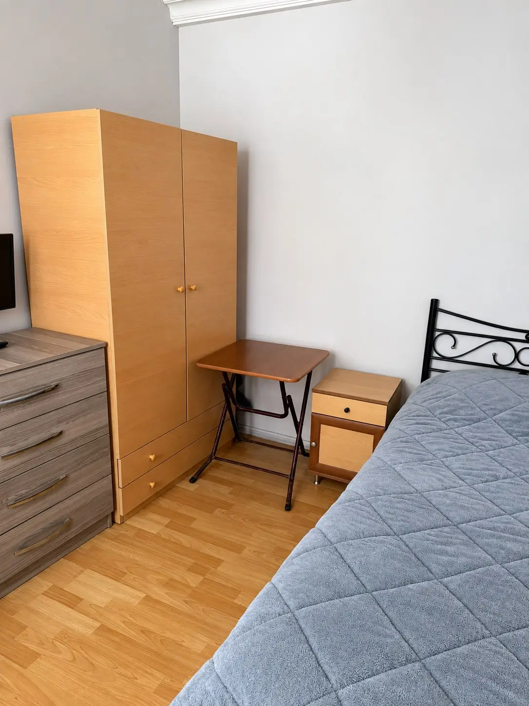 Gardırop, çekmeceli dolap, katlanır masa ve komodinin bulunduğu düzenli oda